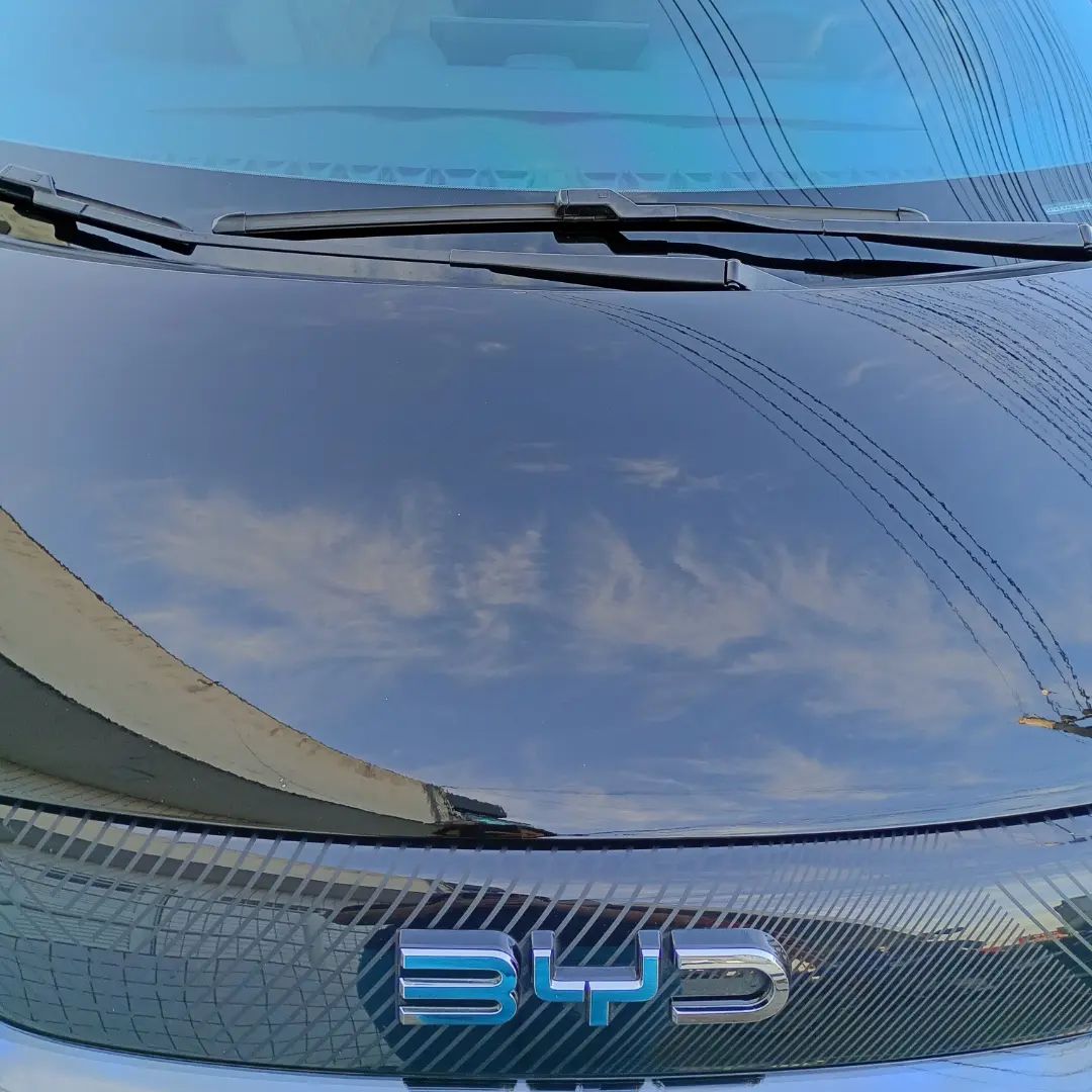 Capô preto com proteção e reflexo do céu